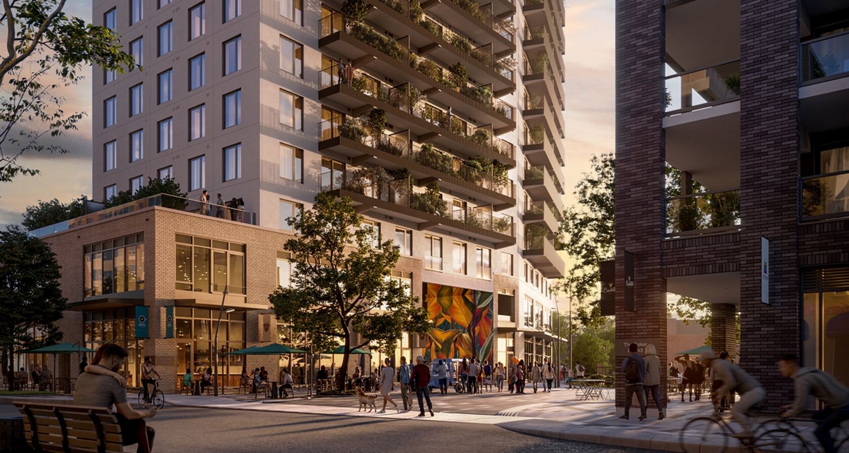 Rendering showing couple sitting on bench facing street with people walking and cycling and sitting at patio tables under umbrellas beside a building that has a rooftop terrace and balconies with greenery