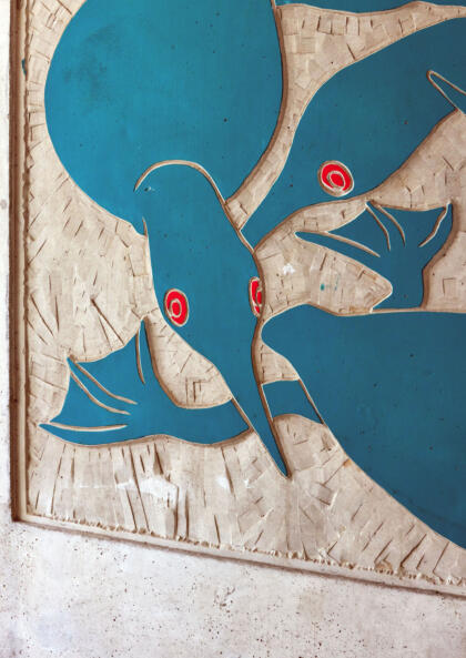 Detail shot of public art panel, depicting stylized shapes of loons in blue with red eyes